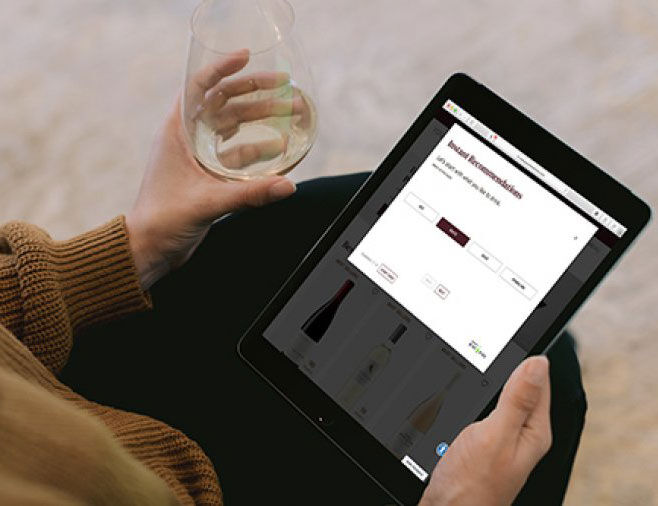 Women on tablet shopping for wine with wine glass
